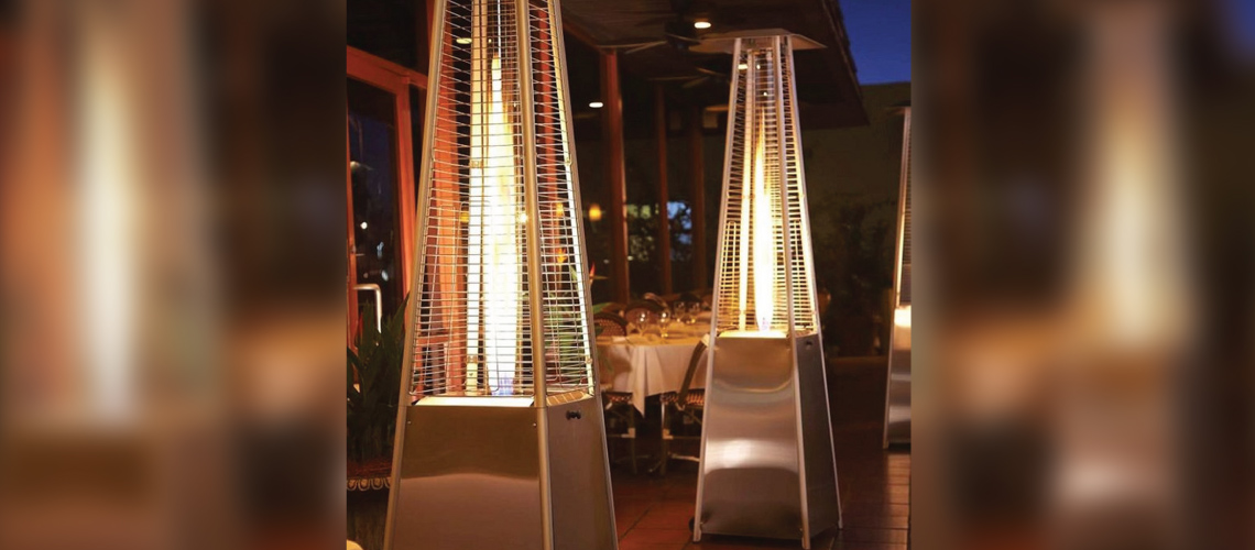 three stainless steel liquid propane pyramid-shaped patio heaters next to tables at an outdoor restaurant patio
