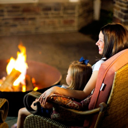 mother and daughter by a lit fire pit