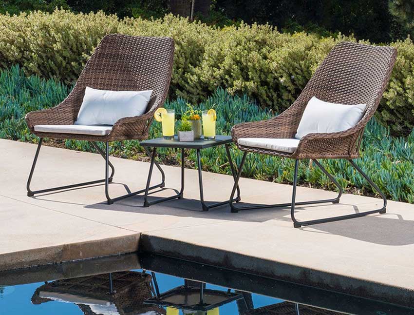 two modern looking patio chairs sitting next to a pool