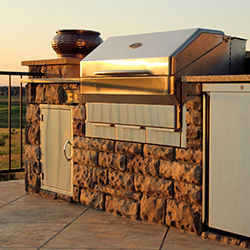 a pellet grill in a stone island at sunset