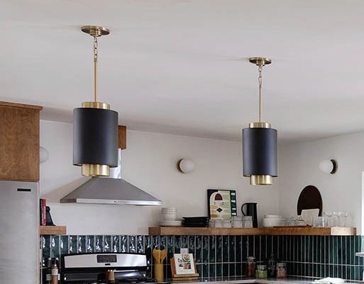 two stylish dramatic bedroom sconces attached to a wood slat wall on either side of a bed with blue and cream bedding